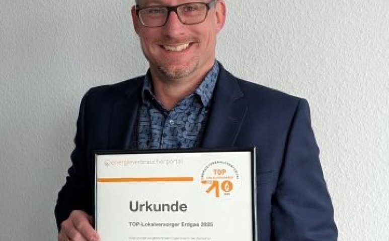 Geschäftsführer hält Urkunde in der Hand